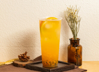 Korean Iced pomelo fruit tea served in disposable glass isolated on wooden board side view of...