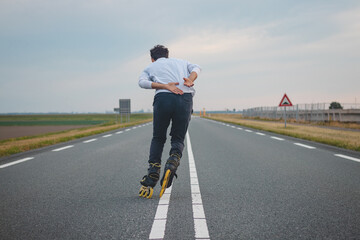 Handsome young athlete rollerblades on Dutch roads to improve endurance and fitness. A young man...