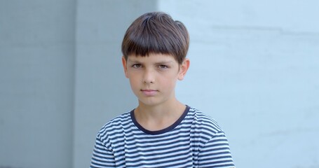 Young boy in striped shirt making direct eye contact with the camera. Use of natural lighting...