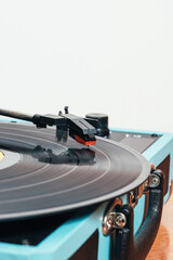 Extreme close up vertical photo of a vinyl on a blue turntable. Copy space. Concept hobbies, art.