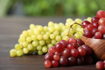 Different fresh ripe grapes on dark wooden table, closeup