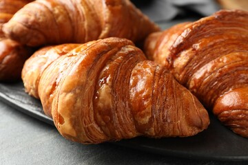 Delicious fresh croissants on grey table, closeup