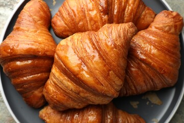 Delicious fresh croissants on grey table, top view