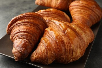 Delicious fresh croissants on grey table, closeup