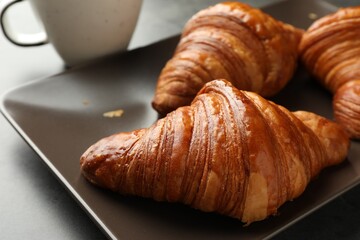 Delicious fresh croissants on grey table, closeup