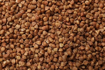 Dry buckwheat grains as background, top view