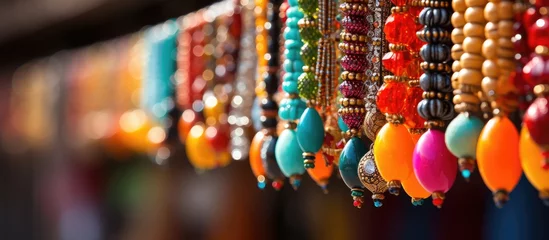 Poster Colorful beaded necklaces hanging in an outdoor market © Vusal