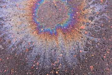 A fuel or oil stain on wet asphalt on a rainy day