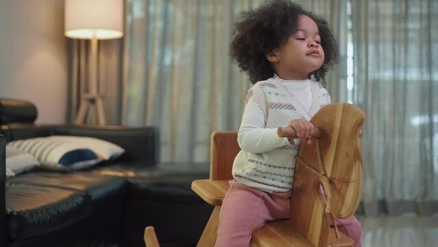Happy African American girl playing in living room at home