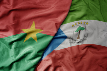 big waving national colorful flag of burkina faso and national flag of equatorial guinea .