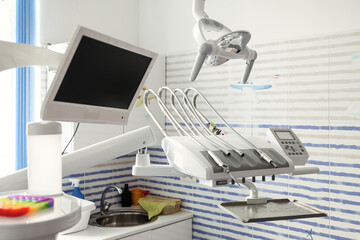 Professional stomatological equipment for doctor in dentist office. Cozy kids dental room in new modern stomatological clinic. Backdrop of accessories used by dentists in blue medic light. Copy space