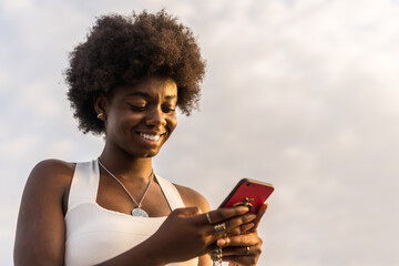 Low angle view portrait of an afro woman using phone