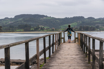 Naklejka premium Woman on the pier contemplating the Ría de Villaviciosa, Asturias