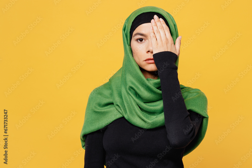 Wall mural young arabian asian muslim woman wear green hijab abaya black clothes cover half face with palm hand