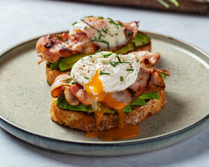 poached eggs on a bed of avocado and bacon 