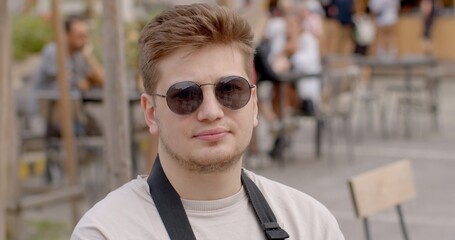 Portrait of young man in urban environment. Sunglasses are protective eyewear designed to shield...