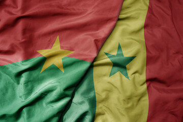 big waving national colorful flag of burkina faso and national flag of senegal .