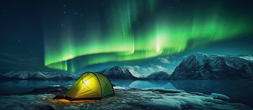 Composite photo of a luminous camping tent amidst a stunning green aurora set in a scenic travel landscape
