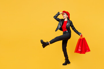 Full body young woman wear casual clothes red hat hold shopping paper package bag keep hand at...