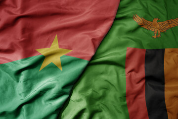 big waving national colorful flag of burkina faso and national flag of zambia .