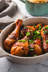 Chicken drumsticks with sesame seeds and rice, Asian cooked chicken close up on the table vertical photo