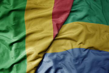 Obraz premium big waving national colorful flag of mali and national flag of gabon .