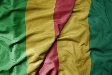 big waving national colorful flag of mali and national flag of guinea .