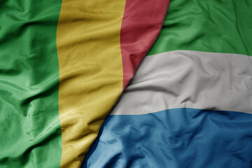 big waving national colorful flag of mali and national flag of sierra leone .