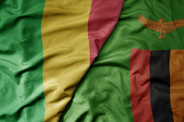 big waving national colorful flag of mali and national flag of zambia .