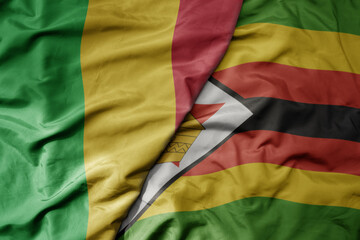 big waving national colorful flag of mali and national flag of zimbabwe .