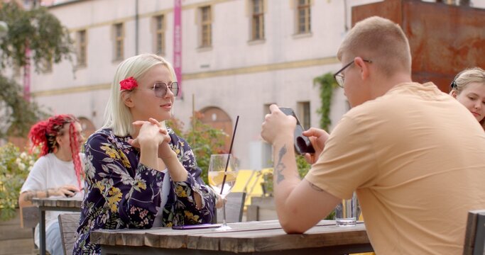 Guy is using his phone during the date. Checking messages, browsing the internet, or using it as a conversation starter or to share something interesting with girl. People lifestyle.