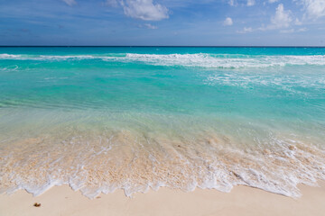 Turquoise water of Caribbean Sea, sandy beach, blue sky, good for background. Cancun, Mexico