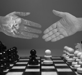 Handshake on white background with chess figures - partnership, merger and acquisition concepts....