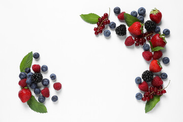 Many different fresh berries and mint leaves on white background, flat lay. Space for text