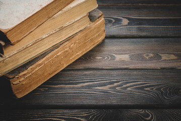 Old vintage books on the retro style wooden table top view background with copy space.