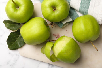 Ripe green apples and leaves on white marble table, flat lay