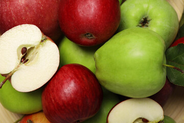 Fresh ripe apples and leaf on wooden plate, closeup