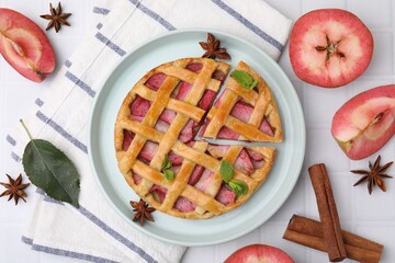 Delicious apple pie with mint and ingredients on white tiled table, flat lay