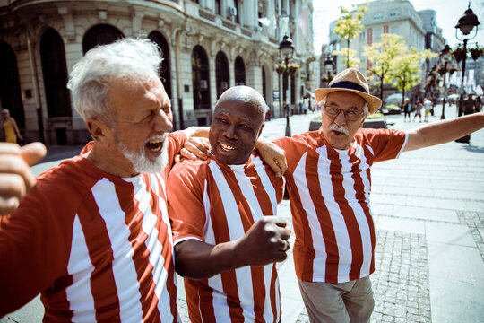 Senior sports fans celebrating a team victory outdoors