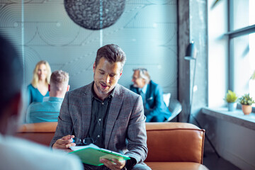 Engaged professional reviews notes during an office gathering