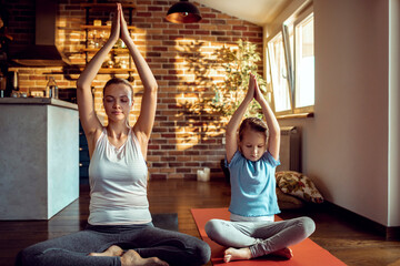 Mother and daughter finding tranquility in synchronized yoga poses