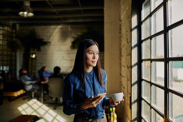 Professional woman enjoying a coffee break in a modern workspace