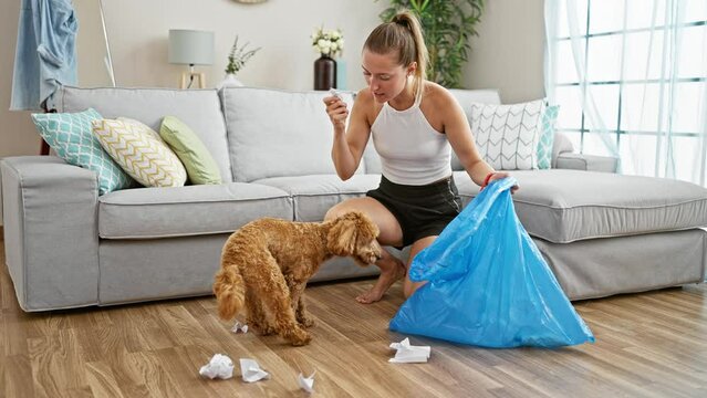 Young caucasian woman with dog breaking trash bag at home