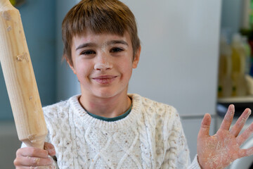 Portrait of child stained with flour because he is cooking