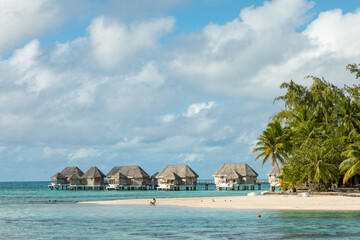 French Polynesia Tikehau atoll with pink coral reef lagoon and overwater bungalows. - obrazy, fototapety, plakaty