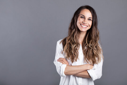 Smiling business woman posing with folded hands. Studio portrait confident businesswoman