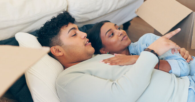 Couple, hug and pointing with boxes in new home after move with real estate, property investment or purchase agreement. Man, woman and married with security in vision for future, family and growth