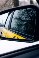 Side mirror of taxi car in motion