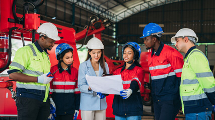 Engineers and foreman inspecting and meeting about the automated arms machine welding robots at factory machines. Worker industry working in the manufacture industrial.