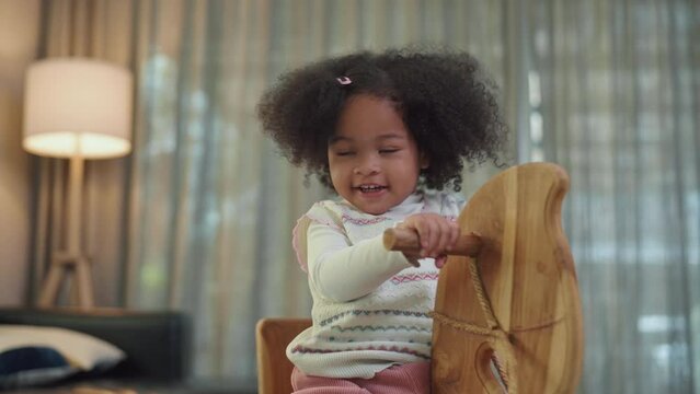 Happy African American girl playing in living room at home